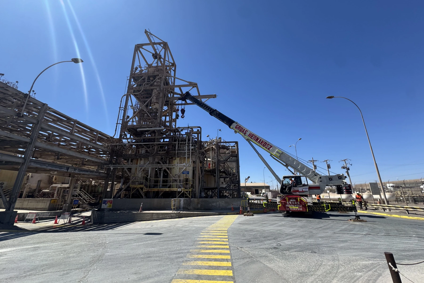 Operación con grúa telescópica en instalación industrial